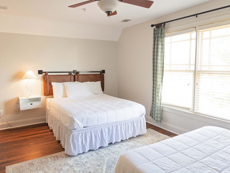 Guest bedroom with two beds and a window